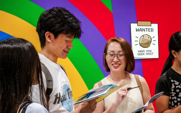Participants engaging in RANSACK PUZZLE HUNT: The Meltdown Menace, examining clues against a colorful backdrop.