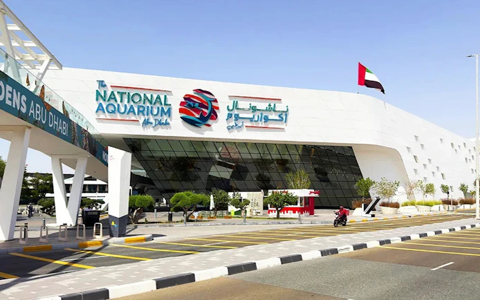 National Aquarium Abu Dhabi entrance with UAE flag and modern architecture.
