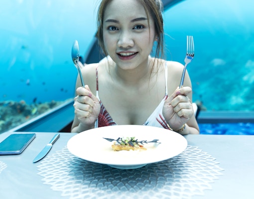 Woman dining with a view of the ocean at Ocean Restaurant.