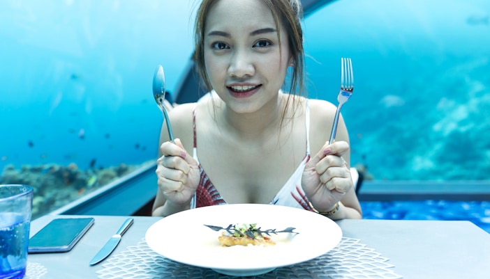 Woman dining with a view of the ocean at Ocean Restaurant.