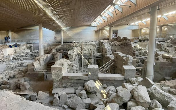 Akrotiri archaeological site ruins in Santorini, Greece, with walkways for guided tours.