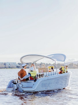 Boating on Lake Burley Griffin with people enjoying a picnic on a rental boat.