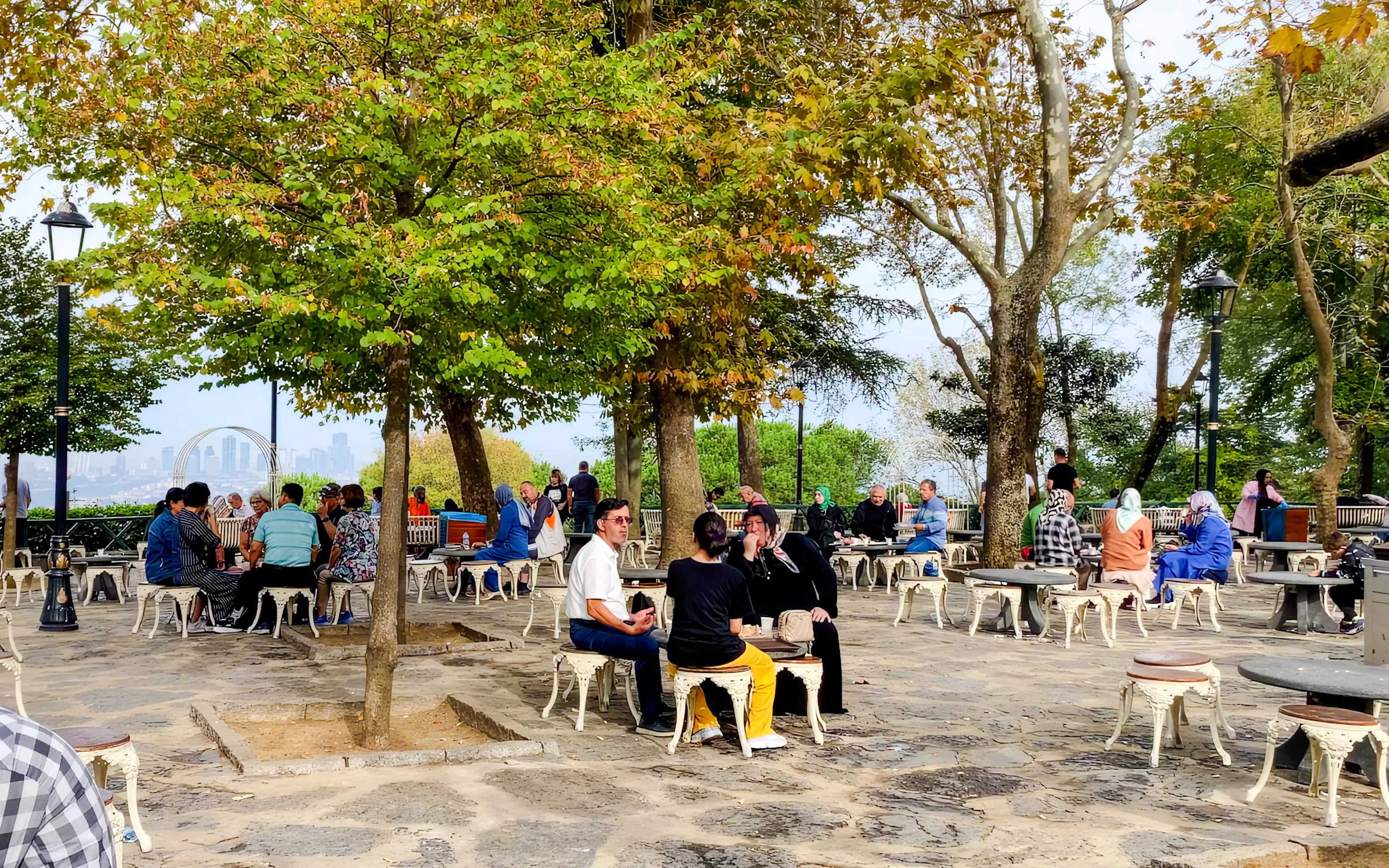 People enjoying outdoor seating at Pierre Loti Hill, Istanbul, with city views in the background.