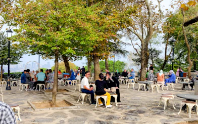 People enjoying outdoor seating at Pierre Loti Hill, Istanbul, with city views in the background.