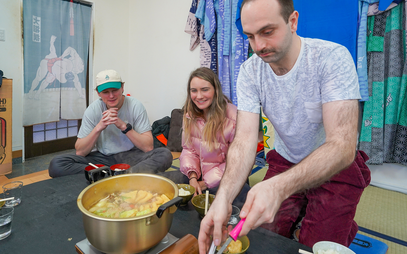 Sumo Wrestling Experience in Tokyo with participants enjoying traditional hot pot meal.