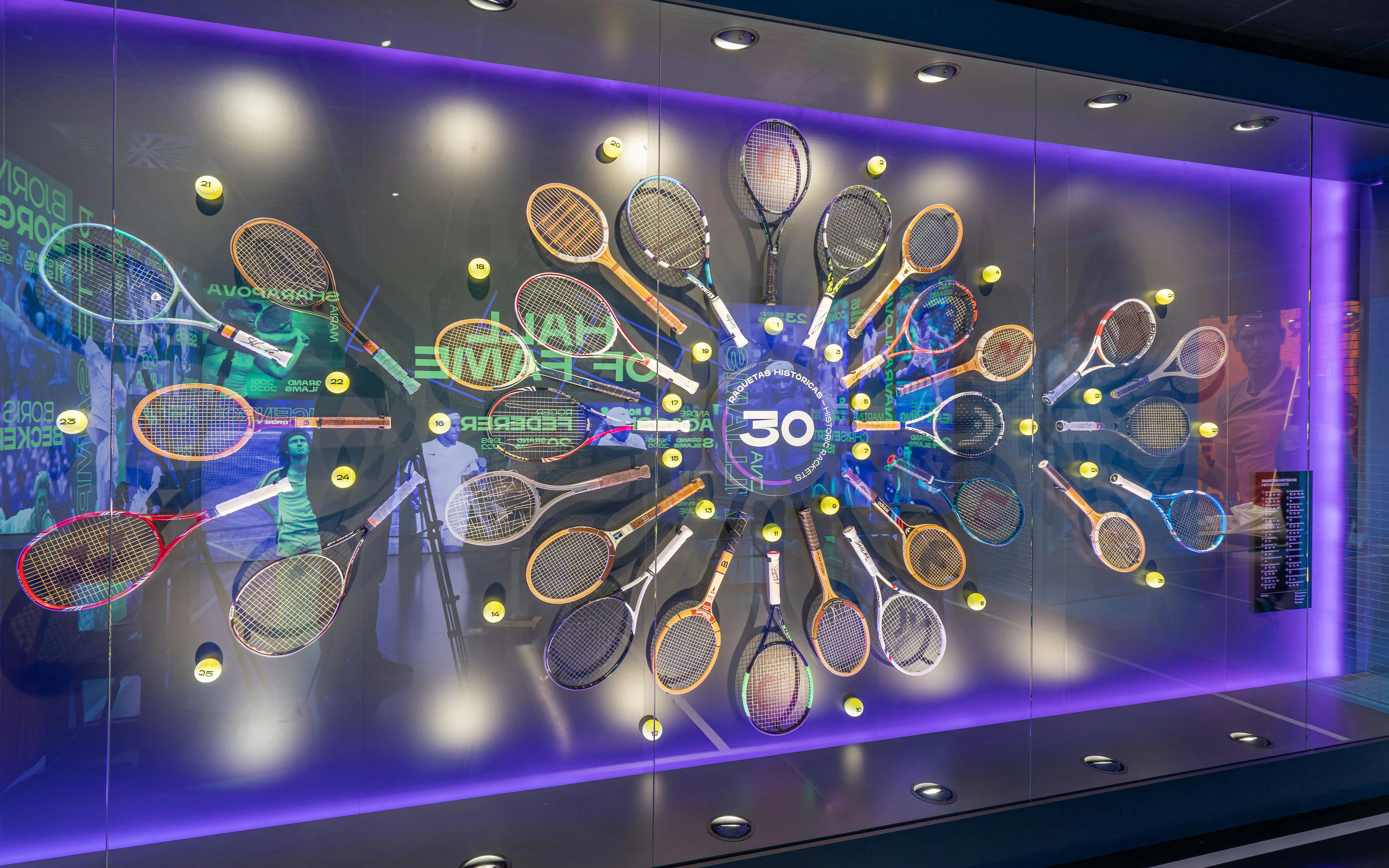 Tennis racket display at Rafa Nadal Museum featuring historic rackets and tennis balls.