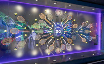 Tennis racket display at Rafa Nadal Museum featuring historic rackets and tennis balls.