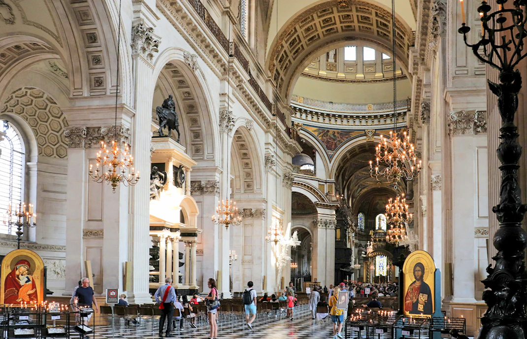St Paul's Cathedral nave with visitors, chandeliers, and religious icon.