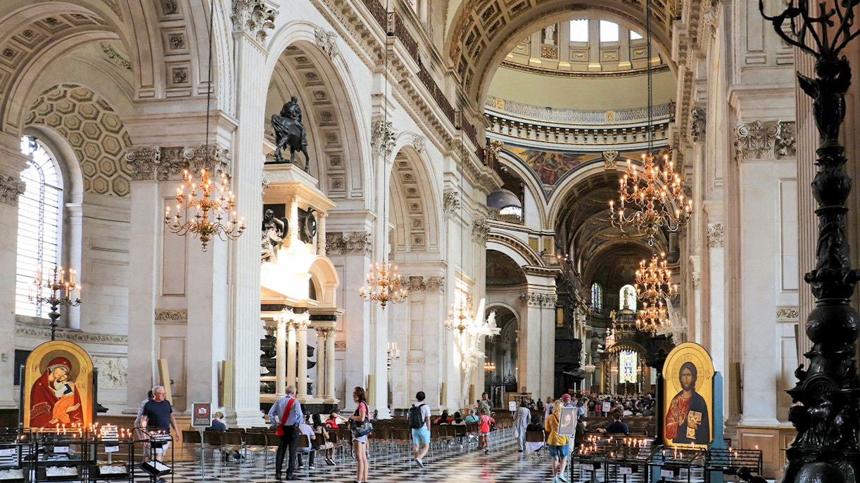 St Paul's Cathedral nave with visitors, chandeliers, and religious icon.