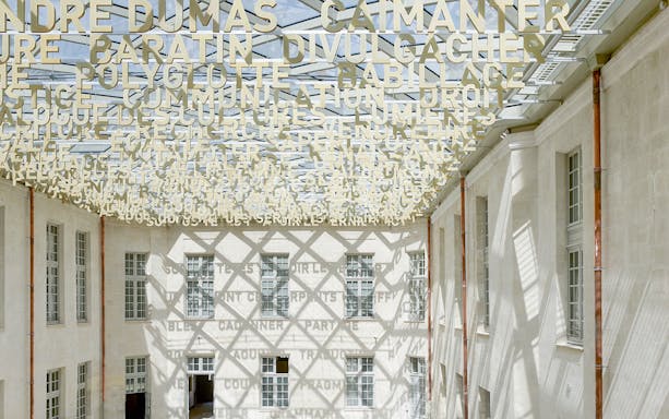 Cité internationale de la langue française courtyard with decorative ceiling text.