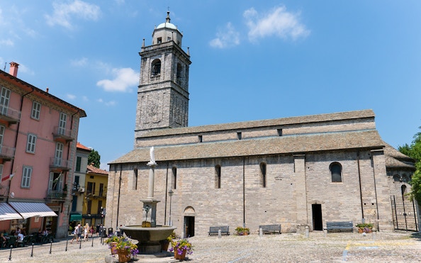 Basilica di San Giacomo in Bellagio with a fountain and Lake Como in the background.