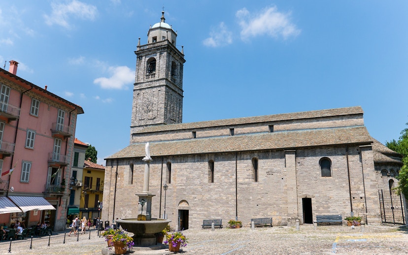 Basilica di San Giacomo in Bellagio with a fountain and Lake Como in the background.