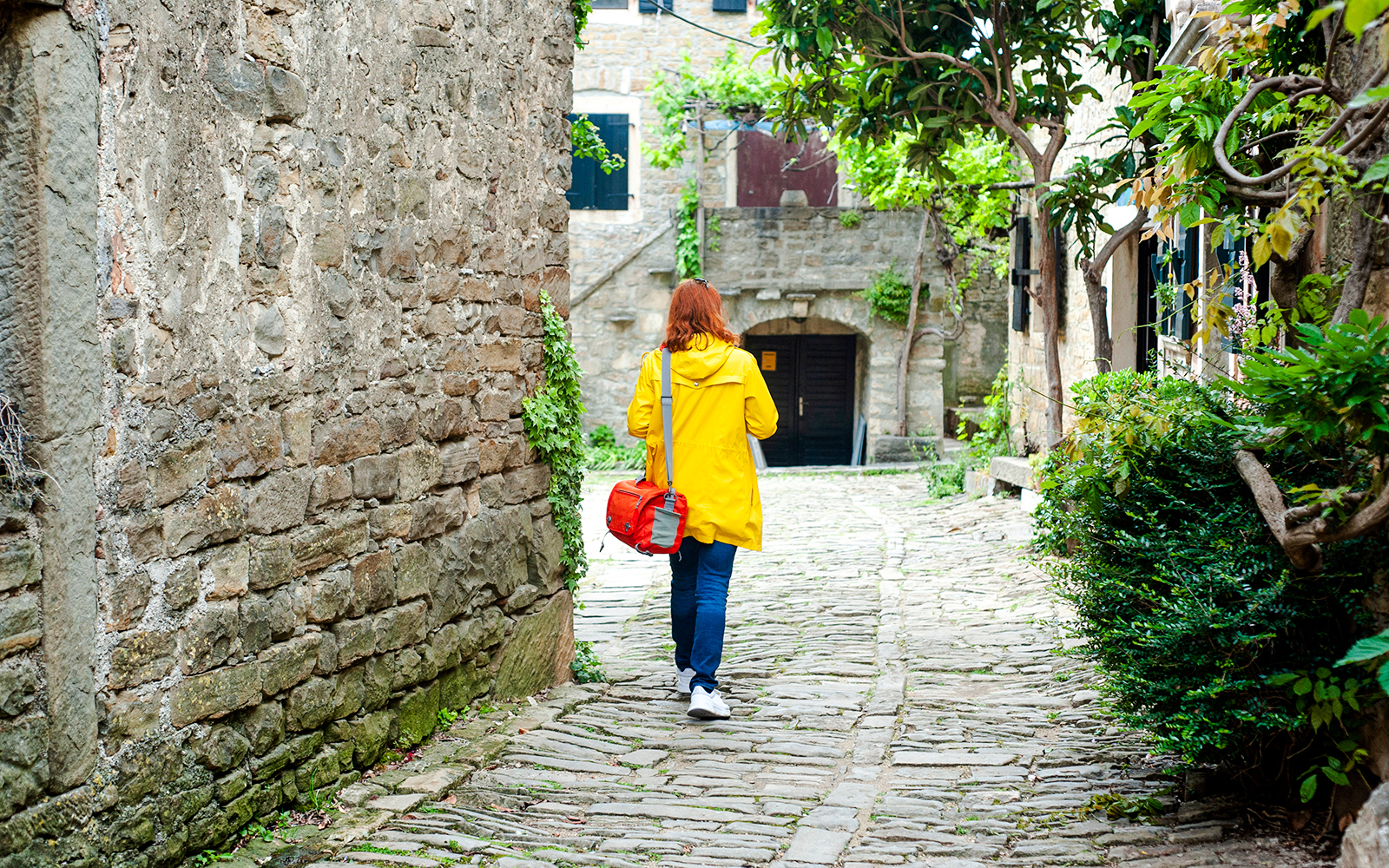 Woman walking on cobbled street in a small Istrian town.