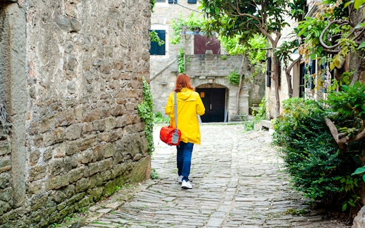 Woman walking on cobbled street in a small Istrian town.