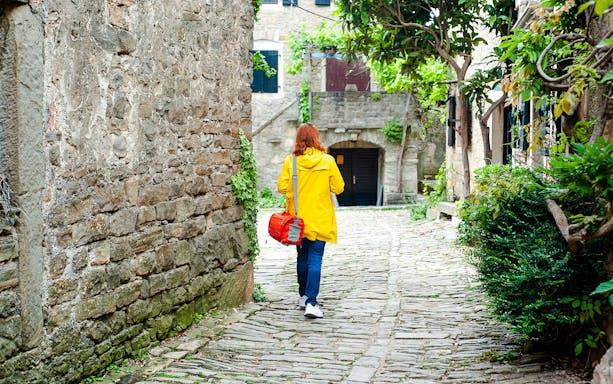 Woman walking on cobbled street in a small Istrian town.