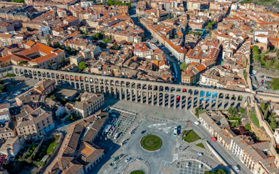 Panoramic view of Segovia with the ancient Roman aqueduct spanning the cityscape.