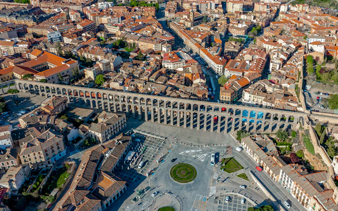 Panoramic view of Segovia with the ancient Roman aqueduct spanning the cityscape.