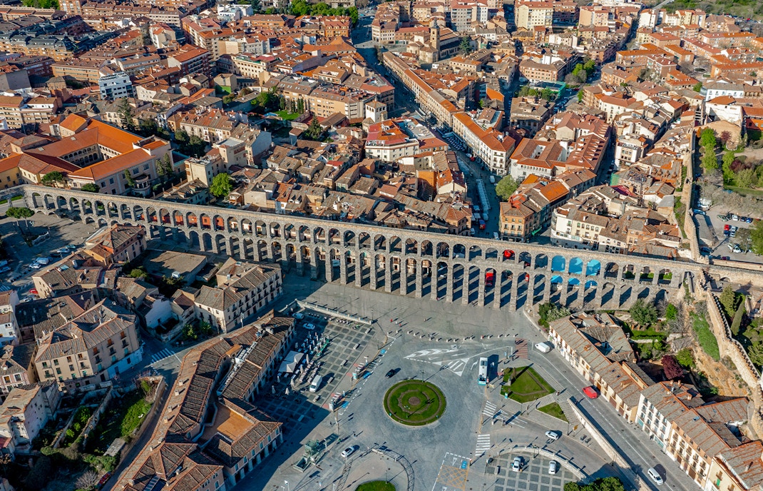 Panoramic view of Segovia with the ancient Roman aqueduct spanning the cityscape.