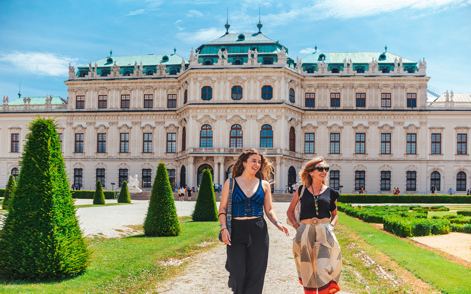Tourists walking on the lawn of Upper Belvedere Palace in Vienna.