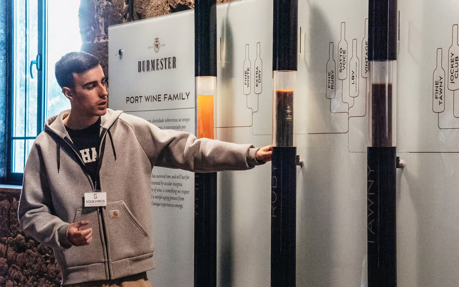 Tour guide explaining port wine history at Burmester winery in Porto.
