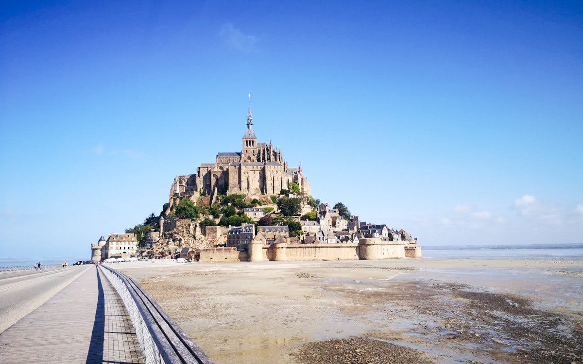 Mont-Saint-Michel Abbey on tidal island with causeway, Normandy, France.