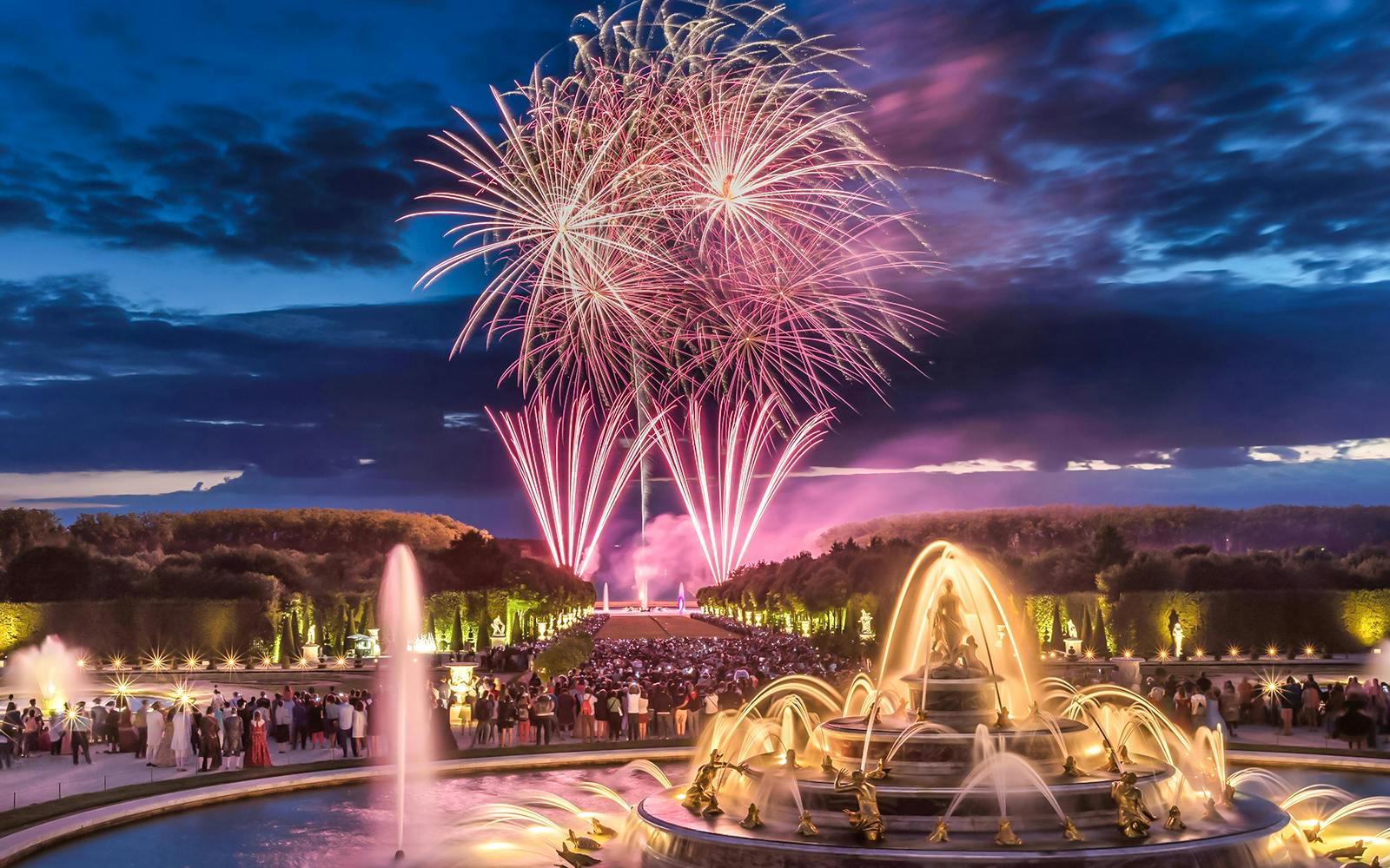 Fireworks over Versailles fountains during night show, viewed from Paris tour.