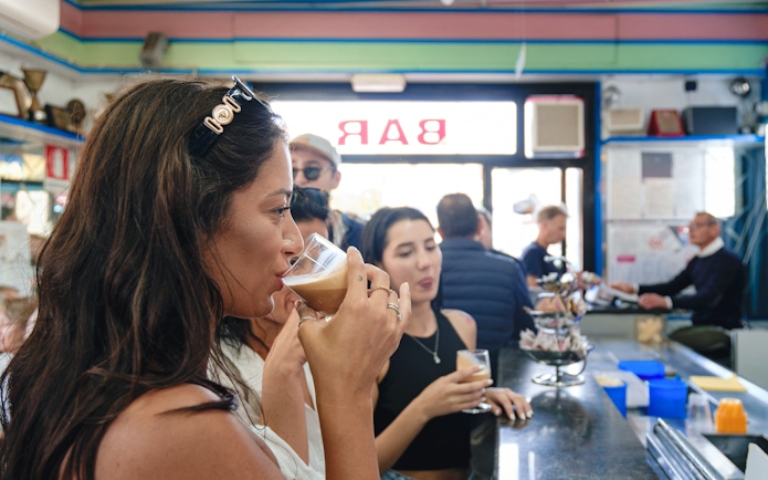 Tourists enjoying coffee tasting at a bar in Polignano a Mare.
