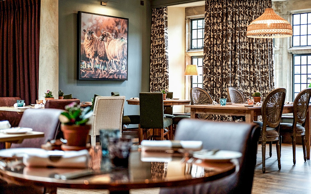 Country pub dining area with rustic decor in the Cotswolds, featuring tables set for lunch.