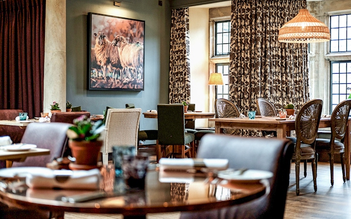Country pub dining area with rustic decor in the Cotswolds, featuring tables set for lunch.