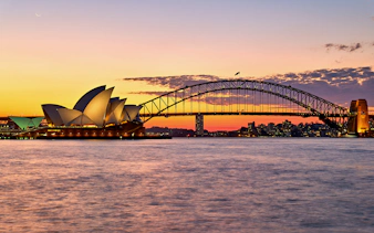 Sydney Opera House and Harbour Bridge at sunset during a harbour cruise.