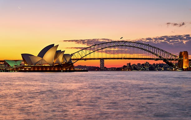 Sydney Opera House and Harbour Bridge at sunset during a harbour cruise.
