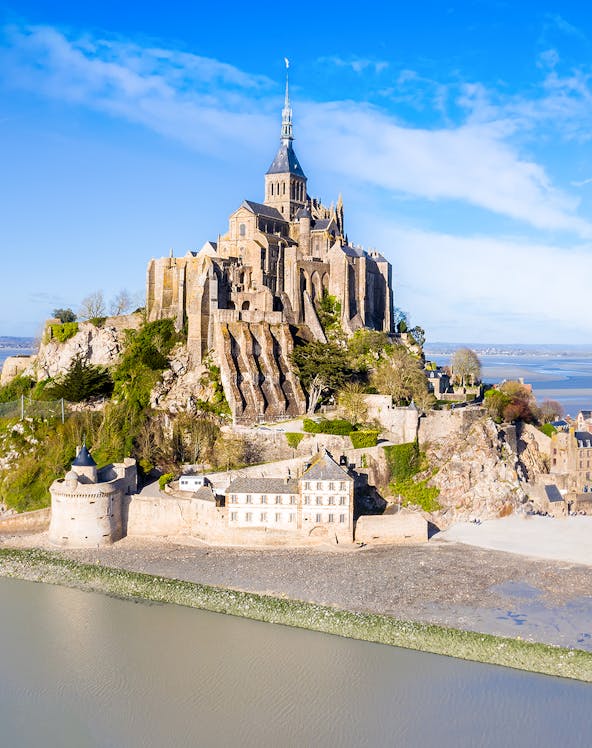 Mont-Saint-Michel abbey on rocky island in Normandy, France, surrounded by water.