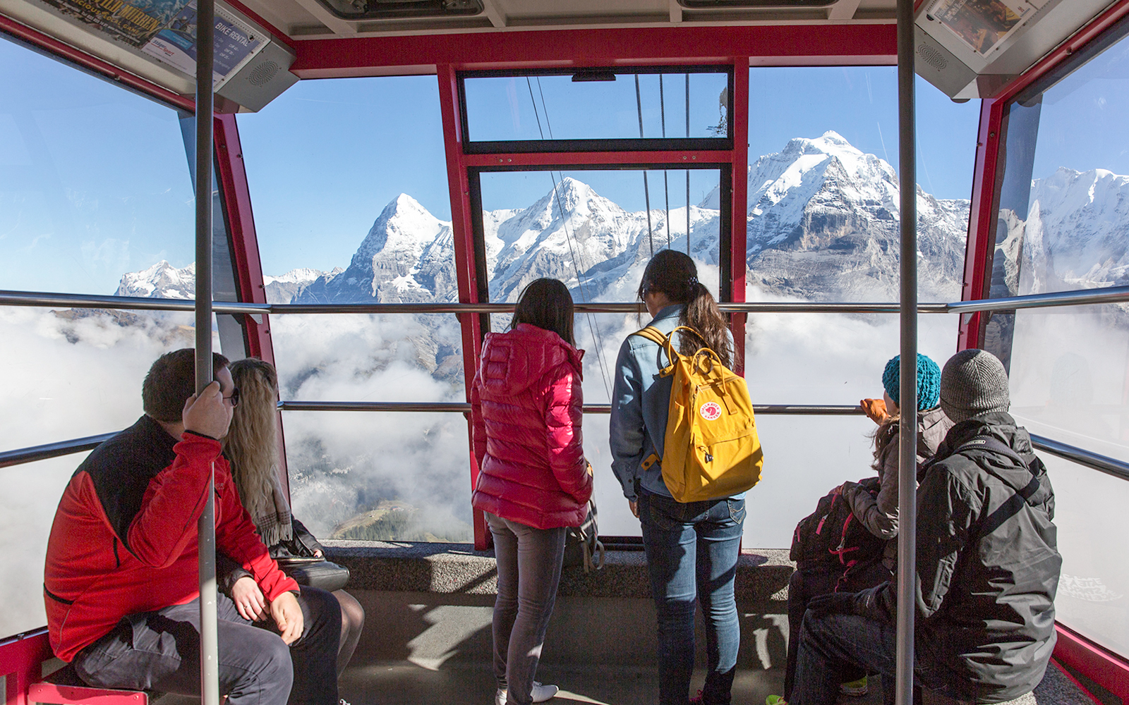 Travelers in a cable car with views of the Swiss Alps, using Swiss Travel Pass Flex.