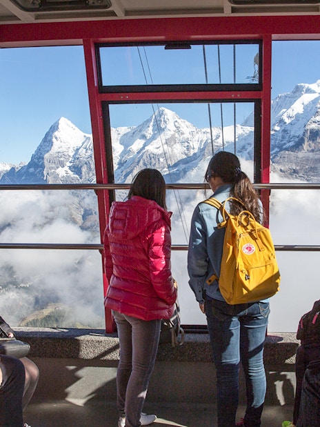 Travelers in a cable car with views of the Swiss Alps, using Swiss Travel Pass Flex.