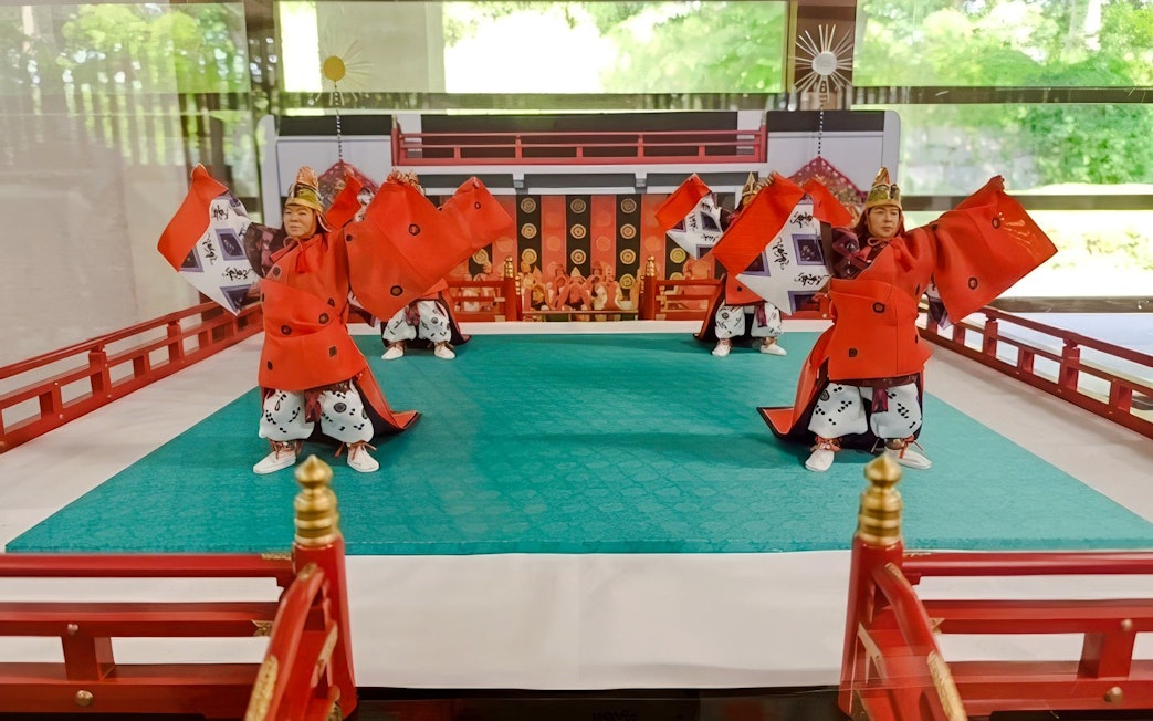 Traditional Japanese dancers in red costumes perform at Tokyo's Imperial Palace.