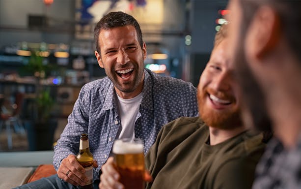 Friends enjoying drinks during a guided pub crawl in Rome.