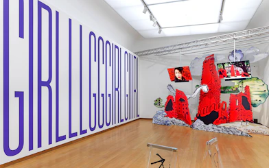 Installation view of "Tomorrow is a Different Day" at Stedelijk Museum featuring large text and red architectural structures.