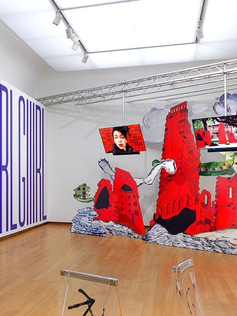 Installation view of "Tomorrow is a Different Day" at Stedelijk Museum featuring large text and red architectural structures.