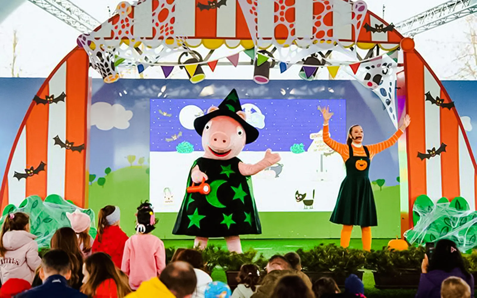 Peppa Pig in a witch costume on stage at Halloween event, PEPPA PIG Park.