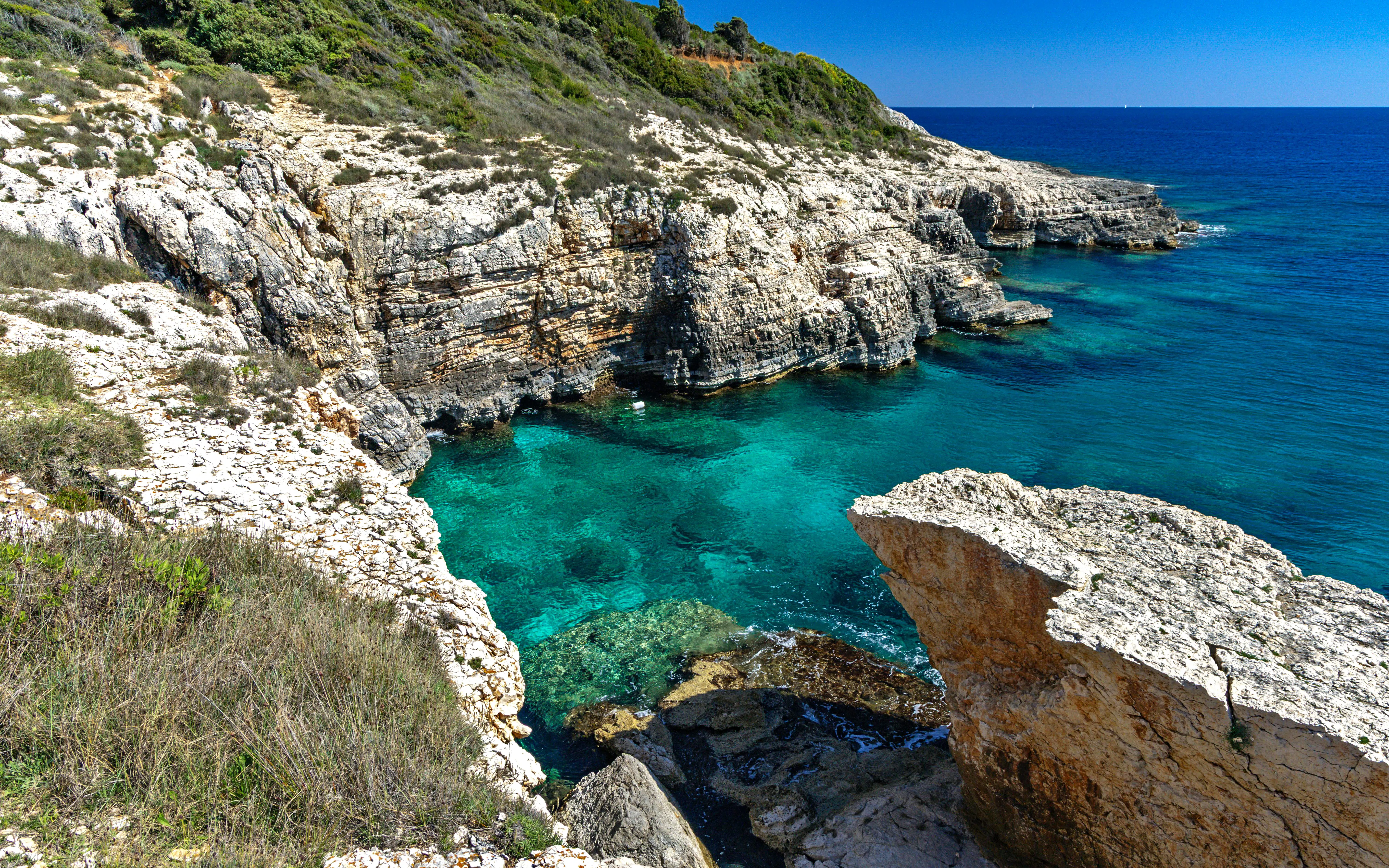 High cliffs and Golumbera Cave at Velika Kolumbarica Beach, Cape Kamenjak, Croatia.