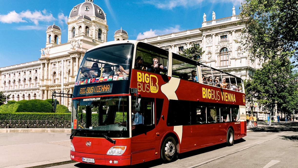Tourists on Big Bus Vienna passing historic building on Hop-On Hop-Off tour.
