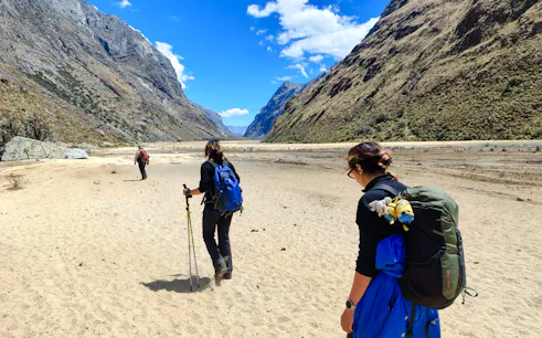 Hikers on Santa Cruz Trek, surrounded by Andean mountains, Vaqueria to Cashapampa, Peru.