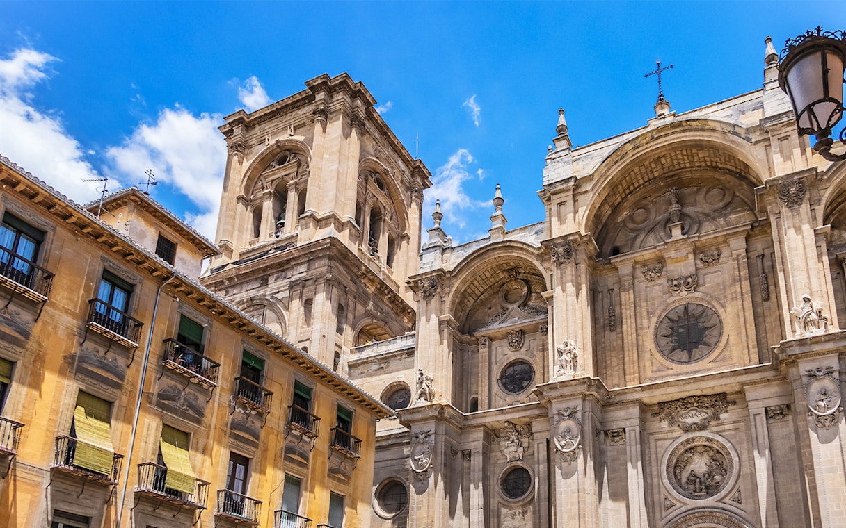 Granada Cathedral facade with ornate architectural details under a clear blue sky.