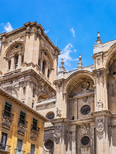 Granada Cathedral facade with ornate architectural details under a clear blue sky.