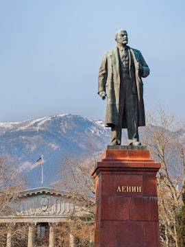 Statue of Lenin at Memento Park, Budapest with mountains in the background.