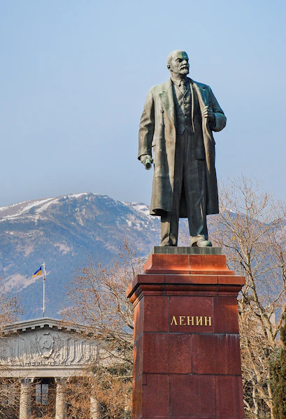 Statue of Lenin at Memento Park, Budapest with mountains in the background.