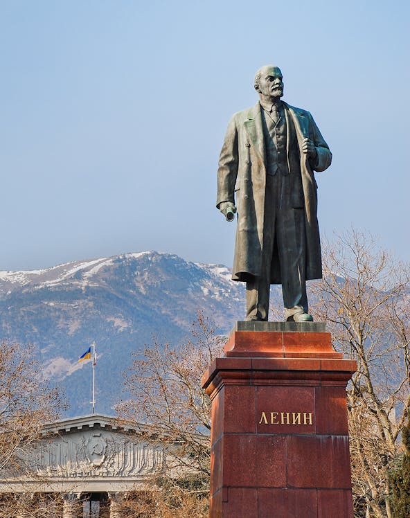 Statue of Lenin at Memento Park, Budapest with mountains in the background.