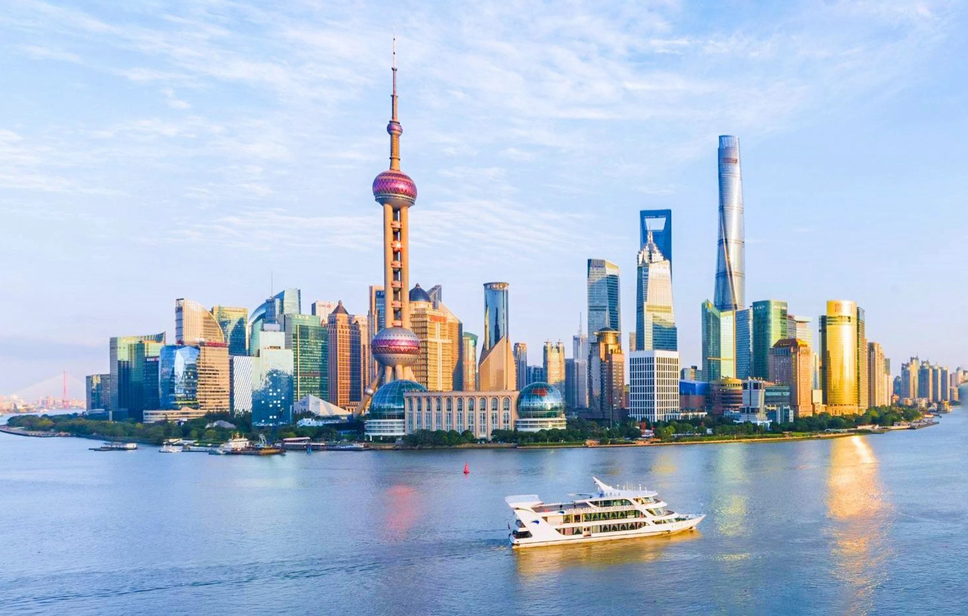 Cruise boat on Huangpu River with Shanghai skyline in the background.