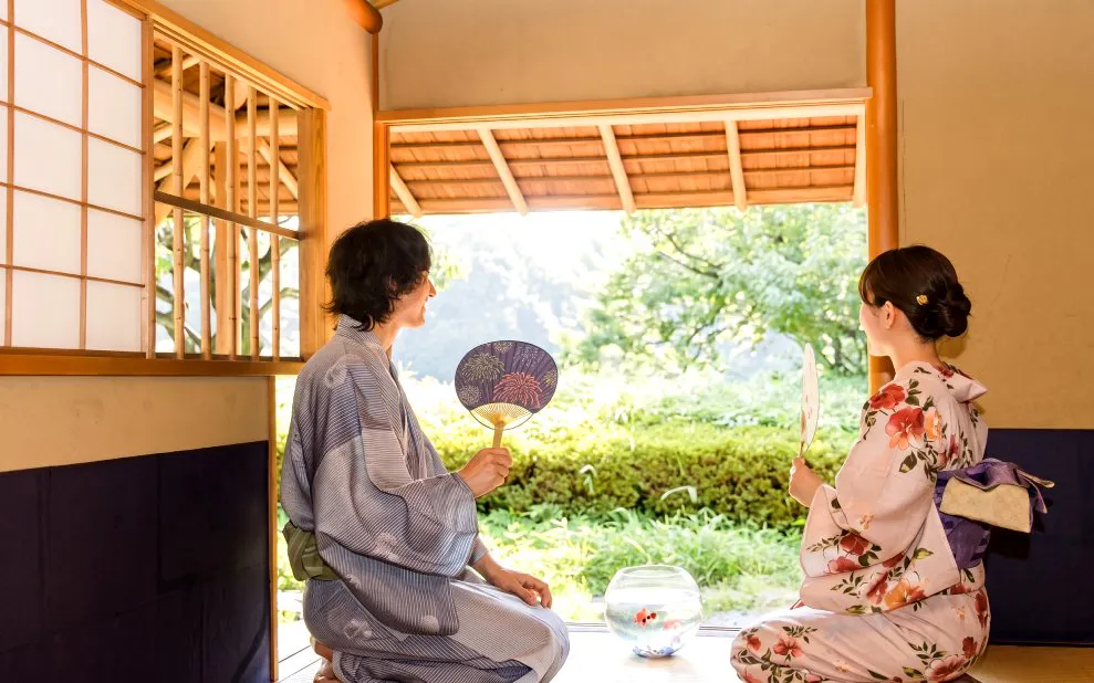 Kimono-clad visitors with fans inside Shinjuku Gyoen National Garden, Tokyo.