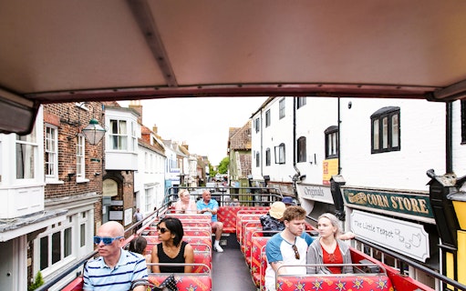 Open-top bus tour in Bournemouth passing historic buildings.